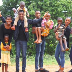 A vibrant and joyful group of family members celebrating together outdoors in Gitega, Burundi.